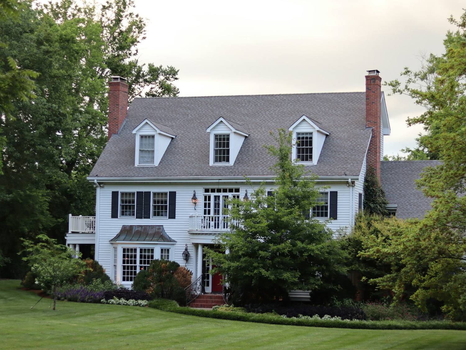 A white colonial home with a red front door